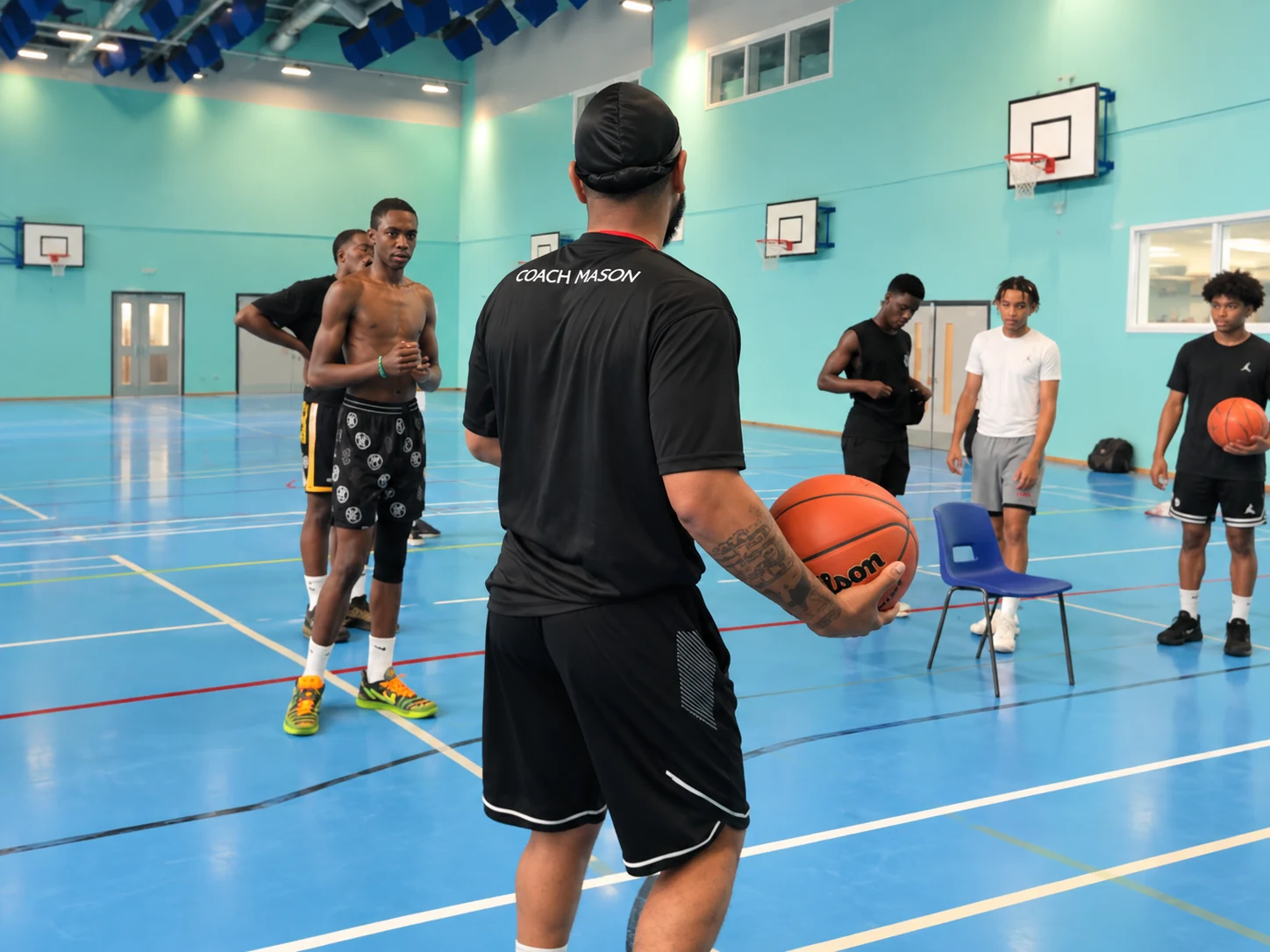 Coach Mason leading a focused basketball session with Holly Lodge players