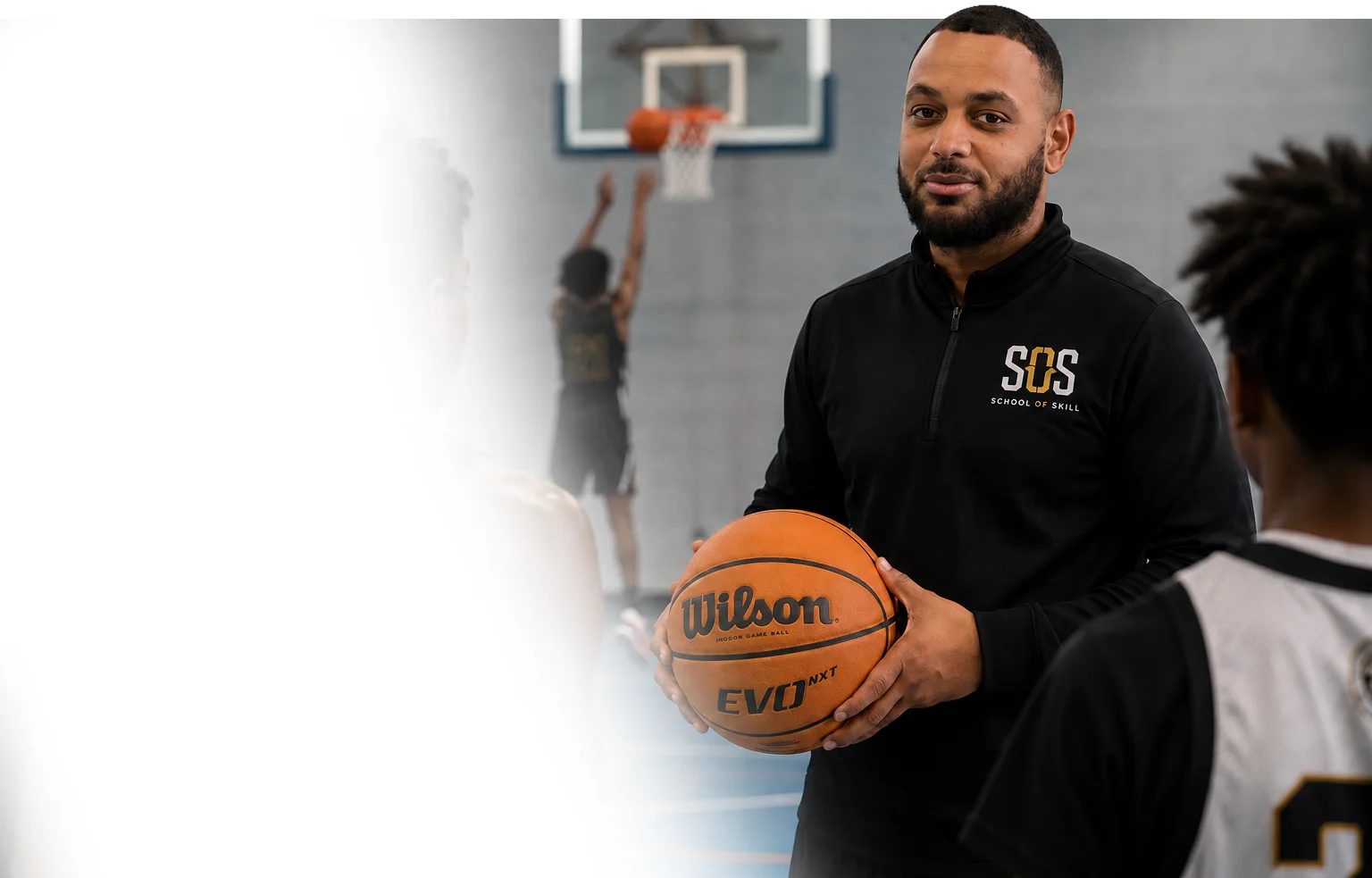 Dailian Mason coaching young basketball players in a sports hall