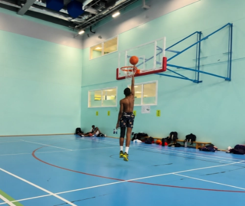 Youth camp players competing in an indoor basketball session