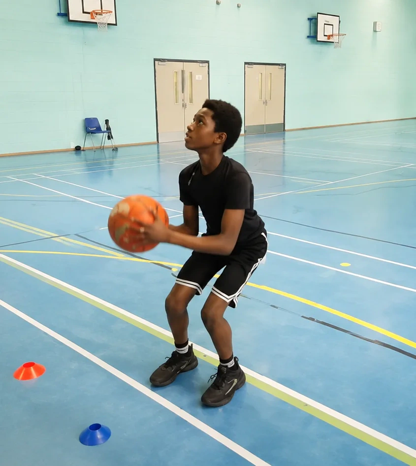 Young player practising shooting technique at youth camp