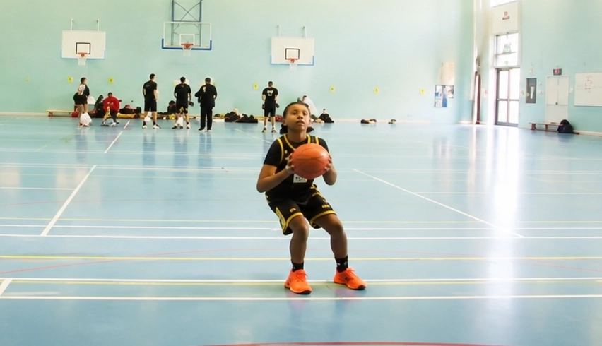 Youth camp players competing in an indoor basketball session